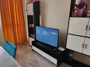 a bedroom with a tv and a desk with a computer at Best apartment- airport in Sofia