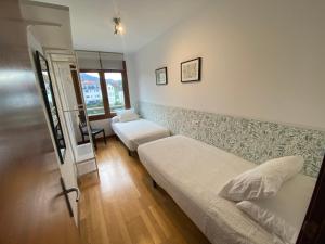 a small bedroom with a bed and a window at Alojamiento Puente del Sella in Cangas de Onís