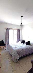 een slaapkamer met een groot bed en een raam bij Zit Flat in Mar del Plata +13 foto's