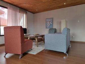 sala de estar con 2 sillas y mesa en видовая квартира в Heredia, en Heredia