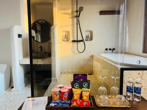a bathroom with a bath tub and a table with drinks at Lotus Home Cafe in Phú Quốc