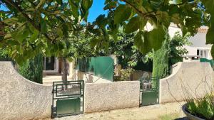 un mur en pierre avec deux portes vertes dans une cour dans l'établissement Au Mont Gaussier, à Saint-Rémy-de-Provence