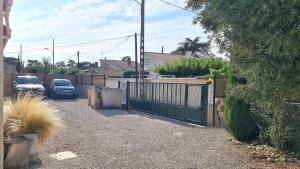 une allée avec un portail et des voitures garées dans une maison dans l'établissement Au Mont Gaussier, à Saint-Rémy-de-Provence