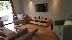 un soggiorno con 2 divani e una TV a schermo piatto di Villa Argaé a Erquy