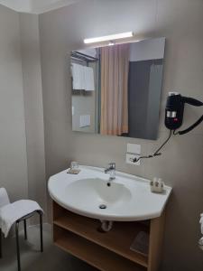 uma casa de banho com um lavatório branco e um espelho. em CityHotel Cristina Vicenza em Vicenza