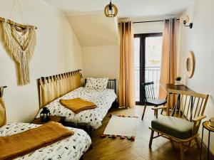 um quarto com 2 camas, uma secretária e uma cadeira em GÓRSKA CISZA - Apartamenty em Stronie Śląskie