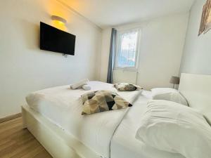1 Schlafzimmer mit 2 Betten und einem TV an der Wand in der Unterkunft Beautiful Apartment Disneyland in Saint-Thibault-des-Vignes