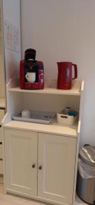 a white cabinet with a coffee maker on top of it at Fam. Honnef in Hannover