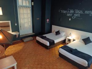 um quarto com duas camas e uma placa na parede em Hostal Regina Down Town Mexico City em Cidade do México