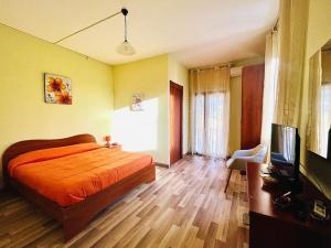 a bedroom with a bed and a flat screen tv at La Bouganville B&B in Acconia