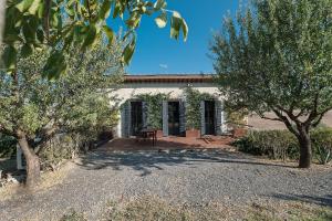 ein altes Haus mit Bäumen davor in der Unterkunft Podere San Pasquale in Castiglione dʼOrcia