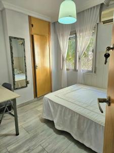 1 dormitorio con cama, ventana y mesa en Habitación Privada a 15 min de la Playa/Piso en Huelva