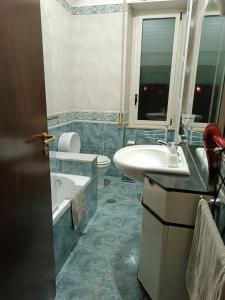 een badkamer met een wastafel, een bad en een toilet bij B&B COLOSSEO in Cosenza