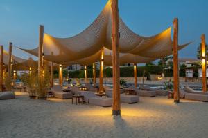 eine Gruppe von Stühlen und Sonnenschirmen am Strand in der Unterkunft Argile Resort & Spa in Lixouri
