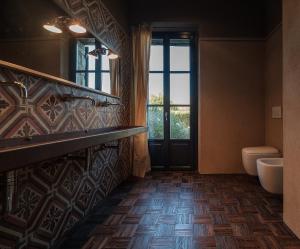 ein Badezimmer mit einem Waschbecken, einem WC und einem Spiegel in der Unterkunft Podere San Pasquale in Castiglione dʼOrcia