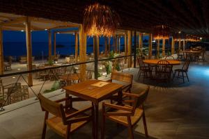 un restaurante con mesas y sillas y vistas al océano en Argile Resort & Spa, en Lixouri