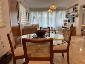 a dining room with a glass table and chairs at Casa Coral in San Felipe de Puerto Plata