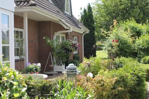 einen Garten vor einem Haus mit Blumen in der Unterkunft Forsthaus Wendt in Timmendorfer Strand