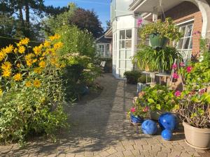 einen Garten mit Blumen und Pflanzen vor einem Haus in der Unterkunft Forsthaus Wendt in Timmendorfer Strand