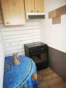 uma pequena cozinha com um fogão e uma mesa em petite maison 15 mn à pied du marche et vieux port em La Rochelle