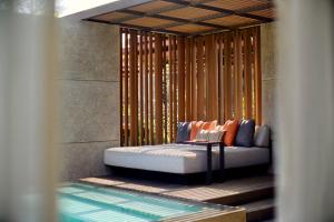 un divano seduto di fronte a un muro di TA’AKTANA, a Luxury Collection Resort & Spa, Labuan Bajo a Labuan Bajo