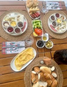 a wooden table with plates of food on it at Kingway Suite in Nusratlı