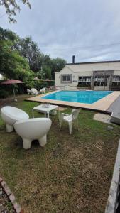 una casa con piscina con due lavandini e sedie di depto 1 dorm complejo Costa Azul Carlos Paz a Villa Carlos Paz