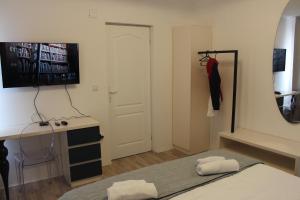 Schlafzimmer mit einem Bett, einem Schreibtisch und einem Spiegel in der Unterkunft Race for Space in Niš