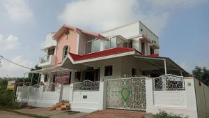 Chittoor的住宿－jayaram Home，粉红色的房子,有白色的栅栏和门