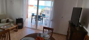 a living room with a table and a living room with a television at Sol y Mar II in Guardamar del Segura