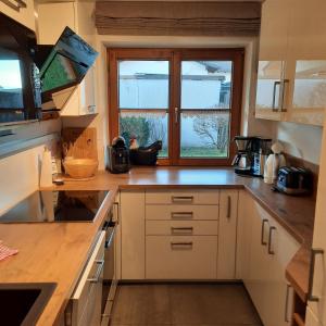 una cocina con armarios blancos y una ventana en Alpenglück, en Burgberg