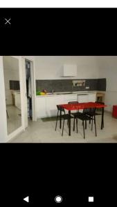 eine Küche mit einem roten Tisch und schwarzen Stühlen in der Unterkunft Mary's house in Portici