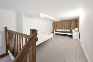 um quarto com uma cama e uma escada de madeira em Block 96 Apartments em Zlín