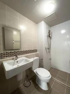 ein Badezimmer mit einem weißen WC und einem Waschbecken in der Unterkunft Cozy and delightful with pool view in Kathu