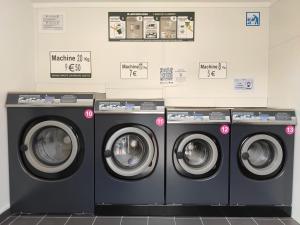 a row of washing machines in a laundry room at LES BERNACHES in Le Crotoy