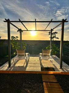 dos sillas en una terraza con la puesta de sol en el fondo en Charming Casa in Majanicho, en Lajares