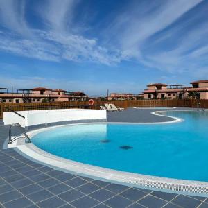 Una gran piscina azul frente a un edificio en Charming Casa in Majanicho, en Lajares