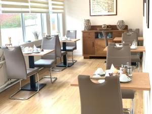 a restaurant with tables and chairs in a room at Pension Haus Beckmann in Borkum