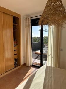 1 dormitorio con una gran puerta de cristal que da a un patio en Charming Casa in Majanicho, en Lajares 18 fotos más