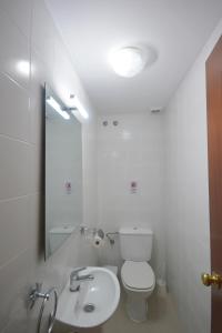 a bathroom with a toilet and a sink and a mirror at Chiclana.Balconera.1ªlínea playa in Chiclana de la Frontera