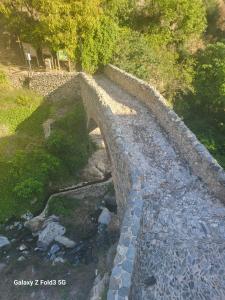 uma velha ponte de pedra sobre um riacho de água em Casa Torre Antigua em Salares