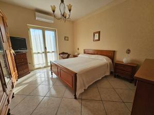 - une chambre avec un grand lit et une télévision dans l'établissement Casa vacanze L'Arco, à Striano
