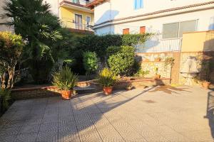 une cour avec des plantes en pot et un bâtiment dans l'établissement Casa vacanze L'Arco, à Striano