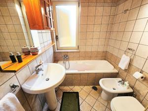 La salle de bains est pourvue d'un lavabo, d'une baignoire et de toilettes. dans l'établissement Casa vacanze L'Arco, à Striano