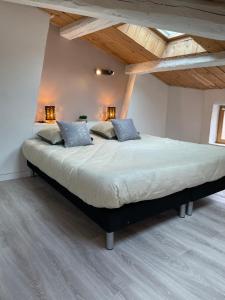 a large bed in a room with wooden ceilings at Le Duplex - Hyper centre - Tout équipé - Parking in Clermont-Ferrand