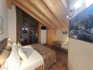a hotel room with two beds and a tv at Hotel Astoria in Courmayeur