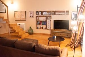 ein Wohnzimmer mit einem Sofa und einem Flachbild-TV in der Unterkunft Da.Ca. Suite in Molfetta