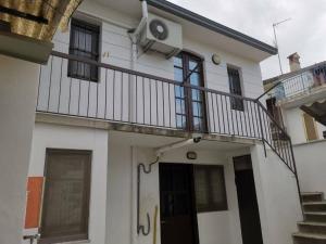 una casa bianca con un balcone sopra di Casa indipendente - Piccolini Hideaway a Vigevano