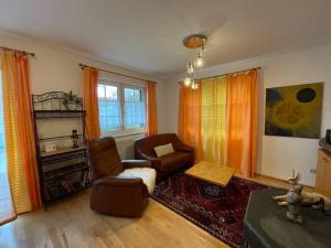 a living room with a couch and a chair at Bungalow in ruhiger Lage in Dietachdorf