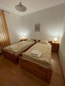two twin beds in a bedroom with two lamps at Bungalow in ruhiger Lage in Dietachdorf